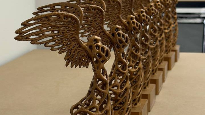 Identical Winged Victory trophies lined up on the production bench